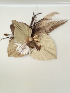 an image of a flower with feathers attached to it's centerpiece on the wall