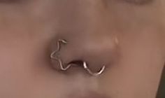 a close up of a person's nose with an open nose ring on it