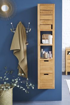 a bathroom with blue walls and wooden furniture in the corner next to a towel rack