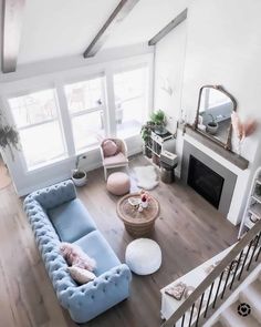 an aerial view of a living room with blue couches and white walls, hardwood floors