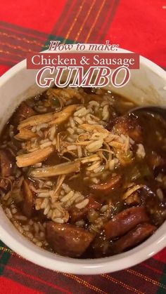 a bowl of chicken and sausage gumbo with rice in it on a red table cloth