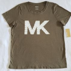 Brand New With Tags Michael Kors Mk Logo Tee Excellent Condition With No Flaws Size Large Approx Measurements Laying Flat: Length 26.5" Armpit To Armpit 22 Across Bottom Hem 22.5" 55% Cotton, 45% Modal Safari (Olive) Green Tee With White Mk Logo And Gold Grommets Crew Neck Style, Short Sleeves, Straight Hem With Side Slits Please No Trades Or Lowballs! *Ask Any Questions You May Have Prior To Making An Offer Please* Michael Kors Cotton Tops For Spring, Casual Michael Kors Short Sleeve Tops, Casual Short Sleeve Michael Kors Tops, Casual Short Sleeve Tops By Michael Kors, Michael Kors Cotton Top With Logo Print, Michael Kors Cotton Crew Neck Top, Michael Kors Cotton Top With Graphic Print, Michael Kors Casual Short Sleeve T-shirt, Casual Michael Kors Short Sleeve T-shirt