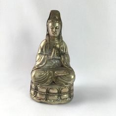 a buddha statue sitting on top of a white surface