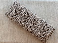 a crocheted piece of cloth sitting on top of a couch