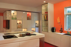 a kitchen with orange walls and white cabinets