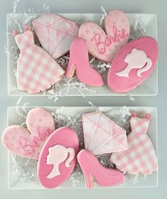 two trays filled with decorated cookies in the shape of baby's shoes and hats