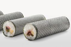 two rolls of sushi sitting next to each other on a white surface with one roll cut in half