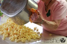 an older woman is pouring corn into a pot