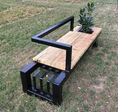 a wooden bench sitting on top of a grass covered field next to a small tree