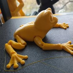 a yellow toy frog sitting on top of a table