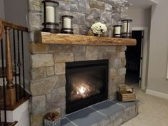 a stone fireplace with lit candles on it