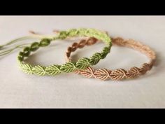 three braided bracelets sitting on top of a white cloth covered table next to each other