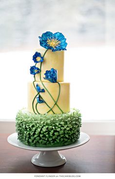 a three tiered cake with blue flowers on top