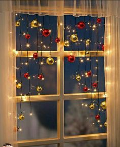 the window is decorated with christmas lights and ornaments