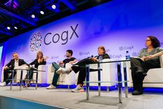 four people sitting on white couches in front of a blue wall with the words cocox