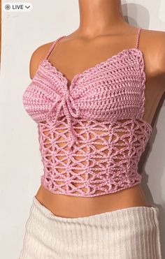 a mannequin wearing a pink crochet top with a bow at the back