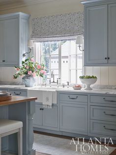 a kitchen filled with lots of blue cabinets and counter top space next to a window