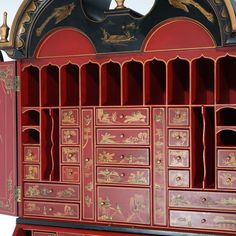 a red cabinet with many drawers on it's sides and gold trimmings