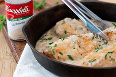 a skillet filled with chicken and gravy next to a can of campbell's soup