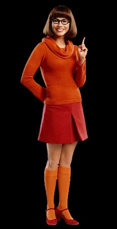 a woman in an orange sweater and red skirt posing with her hands on her hips