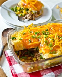 a casserole dish with meat, cheese and green onions