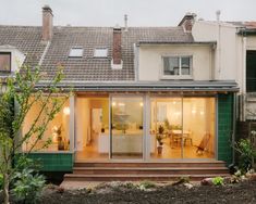 a house that is sitting in the grass with lots of windows and doors on it