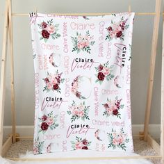 a white blanket with pink flowers on it and the name claire written in cursive writing