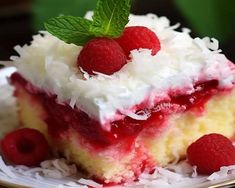 a piece of cake with raspberries and coconut on top