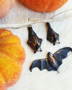 three bats are laying on the fur next to some oranges