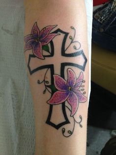 a cross with flowers on it is shown in this tattoo design photo taken by the owner