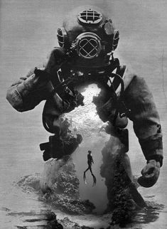 a man in a diving suit with his back to the camera, holding onto an object