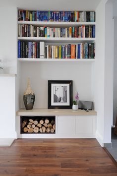 a bookshelf filled with lots of books next to a fireplace