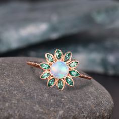 Fire Opal Engagement Ring, Vintage Floral Opal Ring, Rose Gold Opal Emerald Ring, Unique Marquise Halo Cluster Ring, Bridal Promise Ring Promise Anniversary Gift Valentina's day Gift Delicate Opal Ring Bridesmaid Gift For Wife *Primary Stone: Fire Opal *Primary Stone Creation: Lab Created *Stone Color: White *Stone Shape: Round *Stone Size: 6mm Secondary Stone: Emerald Secondary Stone Shape: Marquise Secondary Stone Color: Green Secondary Stone Size: 2x5mm Features: * Handmade * Center Stone Opal  * Brand New * All Ring Sizes Available * Suitable For Every Day * 14k Solid Gold / 18k Solid Gold / Gold Filled Over Sterling Silver * Purity Stamped * Fits True to Size * High Quality * Available Color: Rose Gold, Yellow Gold, White Gold * Band width : 2.5 mm ✦Jewelry Type: Band Metal: 925 Sterl Wedding Ring Opal, Fire Opal Engagement Ring, Opal Wedding Ring, Bridesmaid Rings, Opal Wedding, Precious Rings, Opal Wedding Rings, Ring Opal, Engagement Ring Vintage