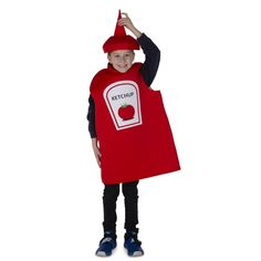 a young boy dressed in a red ketchup costume and holding his hand up