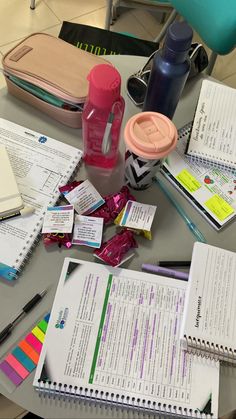 a table topped with lots of papers and pens