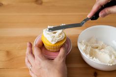 someone is cutting into a cupcake with a knife