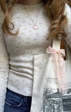 a woman holding a bag with a bow on it