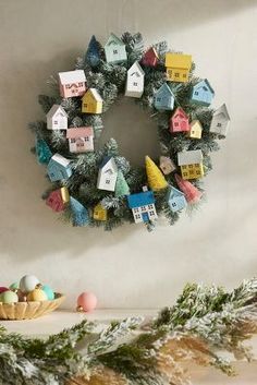 a christmas wreath is hanging on the wall next to other decorations and ornaments, including pine cones