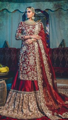 a woman in a red and gold bridal gown