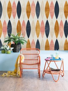 two chairs and a table in front of a colorful wall