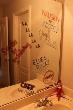 a bathroom mirror with writing on it and a sink in front of the mirror that has no faucet