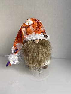 an orange and white hat is on top of a doll's head with hair