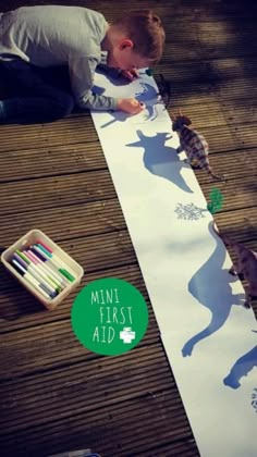 a young boy is making a paper cut out of the shape of a cat and other animals