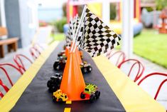 a long table topped with orange cones and race cars