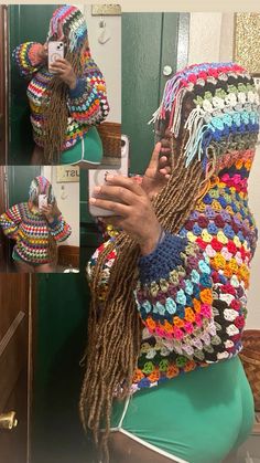 a woman with dreadlocks taking a selfie in front of a mirror wearing a multicolored crochet sweater