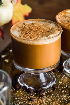 two glasses filled with dessert sitting on top of a metal tray next to each other