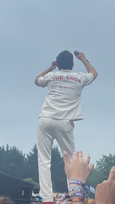 a man standing on top of a person's head in the middle of a crowd