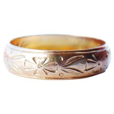 a wedding band with flowers and leaves engraved on it