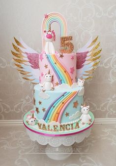 a birthday cake decorated with unicorns and rainbows