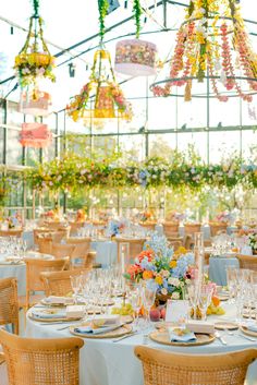 an outdoor dining area with tables, chairs and chandeliers hanging from the ceiling